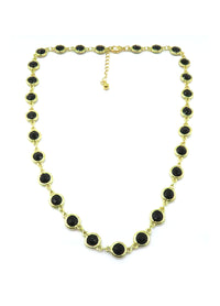 A gold-tone chain necklace featuring multiple oval black stones set in gold bezels, displayed on a clean white background with a small clasp extension.
